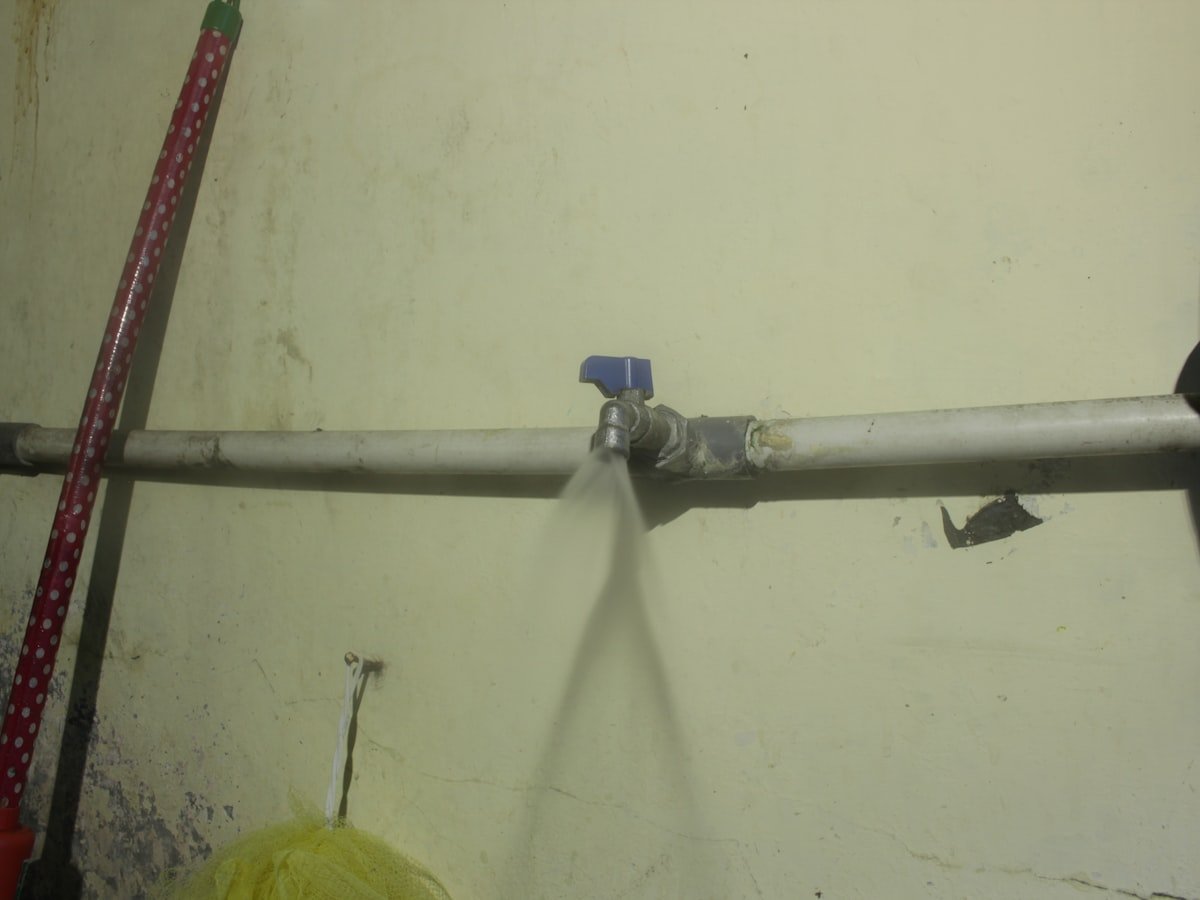 Fuite d'eau jaillissant d'une canalisation réparée par un plombier à Yaoundé